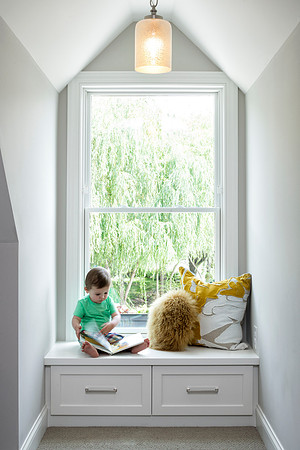 Cute little boy enjoying his book in a stylish dormer nook