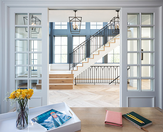 Office with barn doors out to a grand stair case